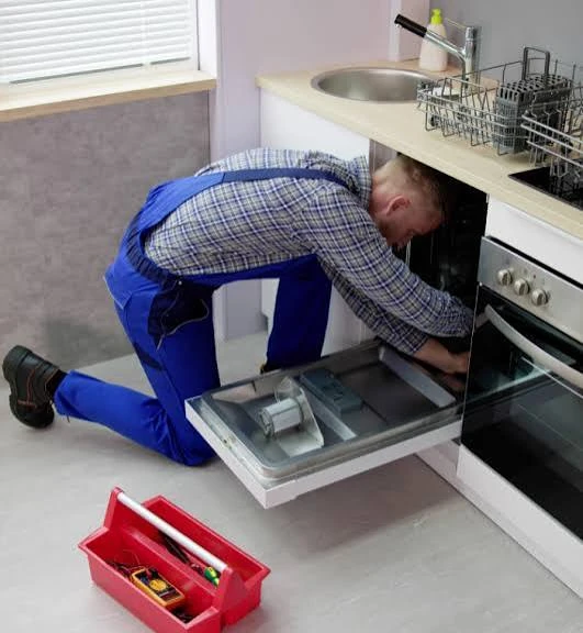 Technician inspecting the inside of an open dishwasher