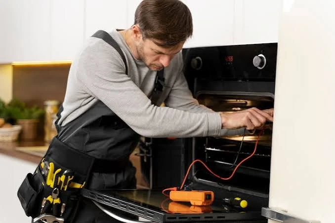 Technician testing a home oven with a multimeter