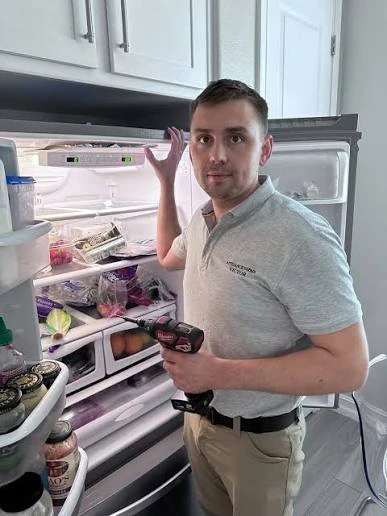 Technician checking a refrigerator in a home kitchen